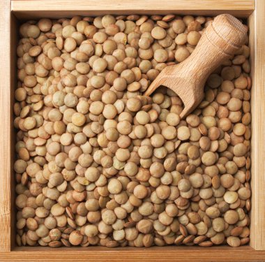 Wooden box full of laird lentils clipart