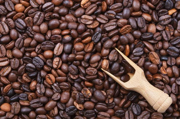 Achtergrond met koffiebonen en houten lepel — Stockfoto