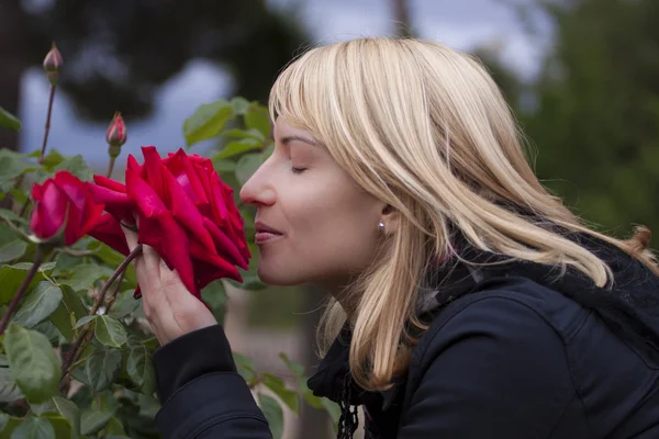 Señora oliendo una rosa ih un parque barroco — Foto de Stock