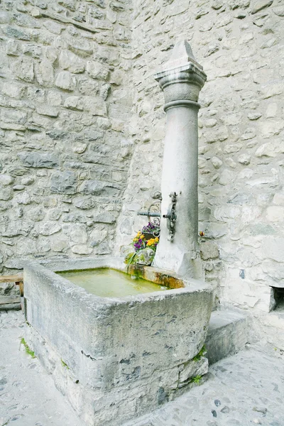 Vecchia fontana in pietra con irrigazione a Chateau Chiilon, Montreux, S — Foto Stock