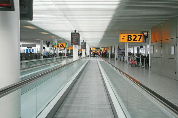 AMSTERDAM - APRIL 14: Passengers move around the terminal at Ams — Stock Photo, Image