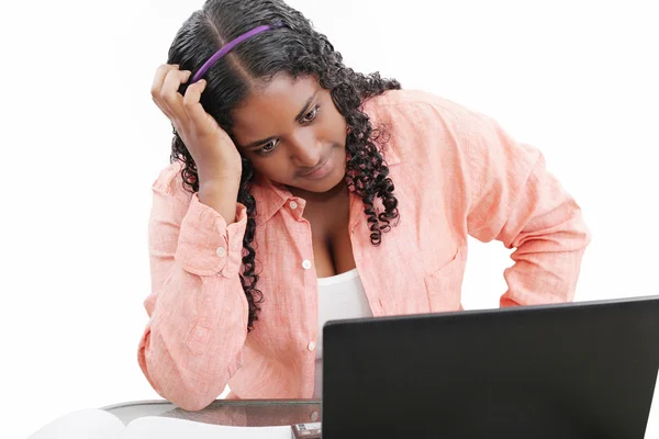Jeune professionnelle noire avec la main dans les cheveux sur ordinateur portable — Photo