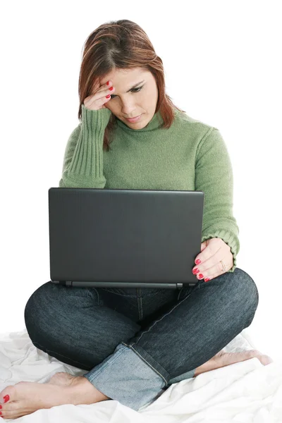 Mujer bonita profunda en el pensamiento mientras mira el ordenador portátil — Foto de Stock