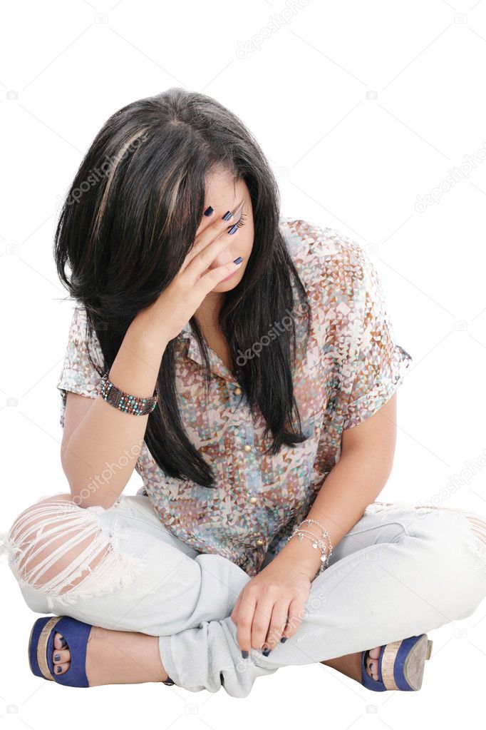 Dejected woman with hands on face sitting on floor