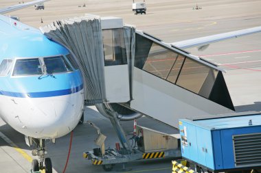 Airplane at an airport with passenger gangway clipart