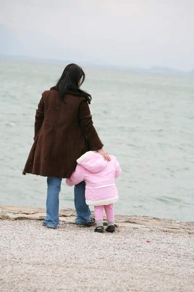 Мать и дочь смотрят на море зимой — стоковое фото