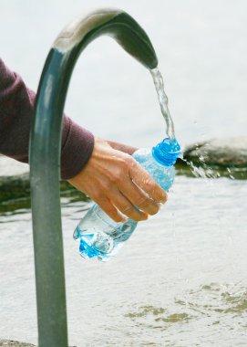 Fountain of spring water bottle filling holding hand in Lugano, clipart