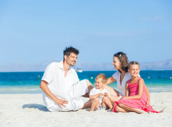 Família de quatro na praia tropical — Fotografia de Stock