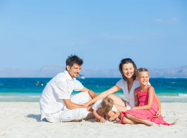 Família de quatro na praia tropical — Fotografia de Stock