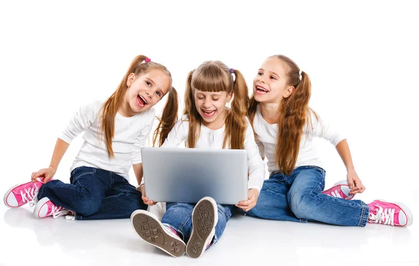 Tre attraktive jenter som bruker en bærbar PC – stockfoto