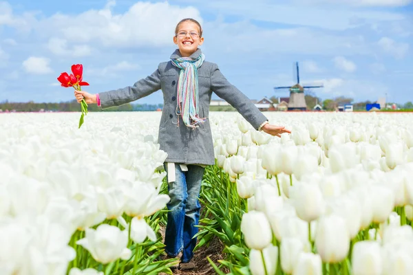 Menina no campo de tulipas roxas — Fotografia de Stock