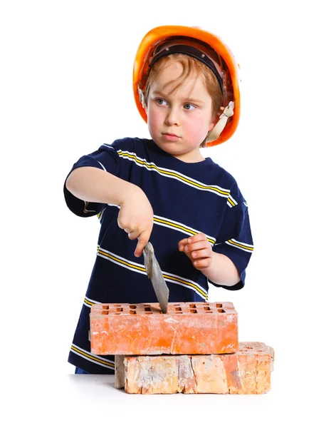 Tuğla ile sert şapkalı çocuk — Stok fotoğraf