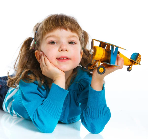Carino bambina che gioca con un aeroplano giocattolo — Foto Stock
