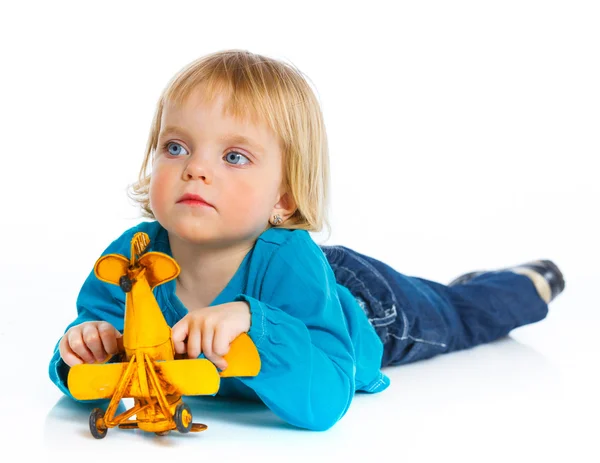 Aranyos kis lány játszik egy játék repülőgép — Stock Fotó