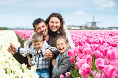 Family having fun on tulips field clipart