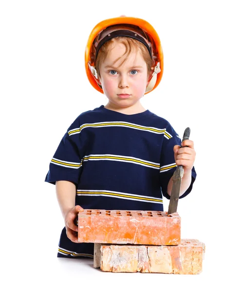 Tuğla ile sert şapkalı çocuk — Stok fotoğraf