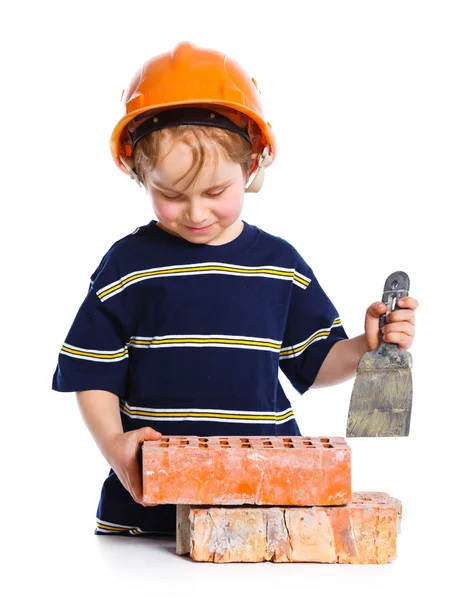 Boy in hard hat with brick — Stock Photo, Image