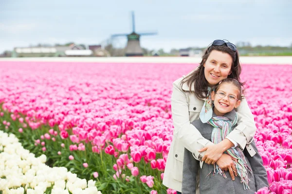 Menina com a mãe no campo de tulipas roxas — Fotografia de Stock