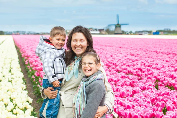 Matka s dítětem v oboru tulipány — Stock fotografie