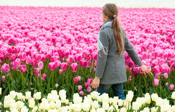 Flicka i fältet lila tulpaner — Stockfoto