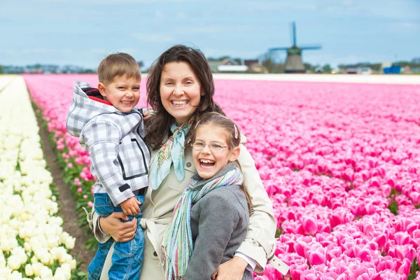 Madre con su hijo en el campo de los tulipanes —  Fotos de Stock