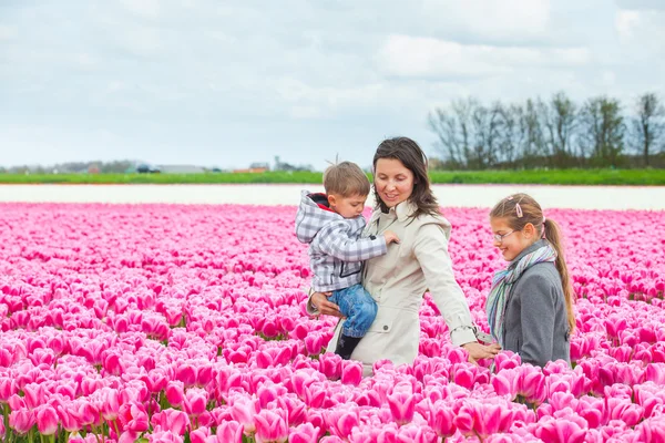 Mère avec son enfant dans le champ de tulipes — Photo