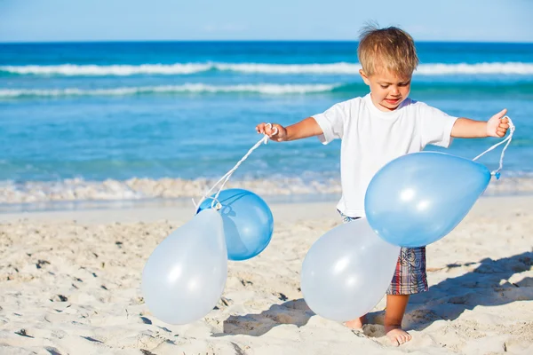 Мальчик играет с шариками на пляже — стоковое фото