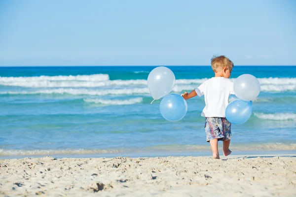 少年はビーチで風船を再生します。 — ストック写真