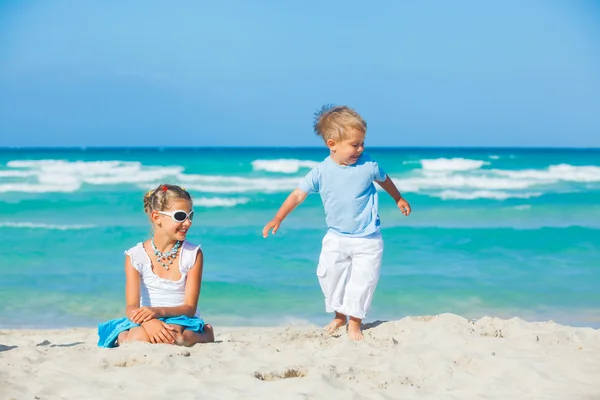 Giovane ragazza e ragazzo giocare felicemente a bella spiaggia — Foto Stock