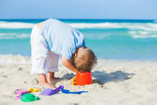 Menino com brinquedos na praia — Fotografia de Stock