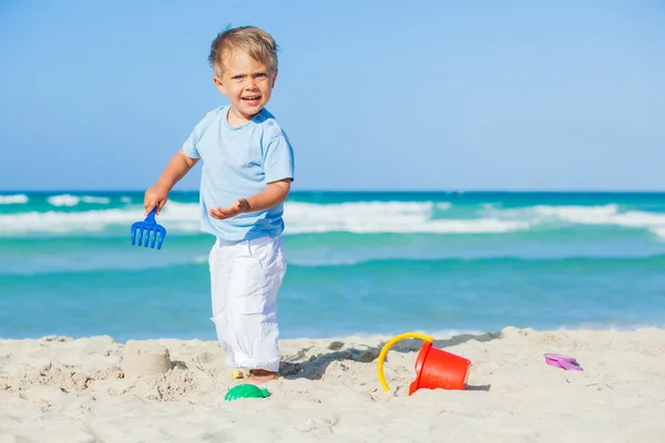 Pojke med leksaker på stranden — Stockfoto