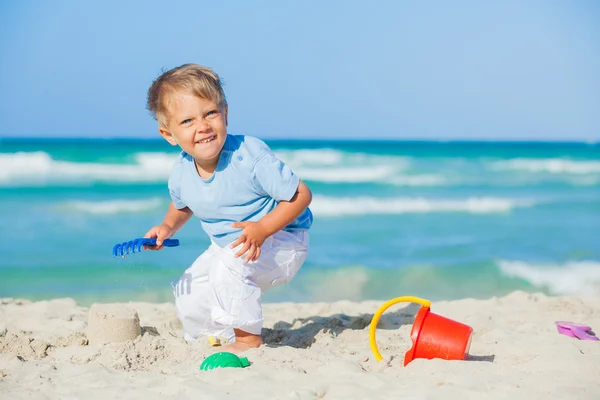 Jongen met speelgoed op strand — Stockfoto