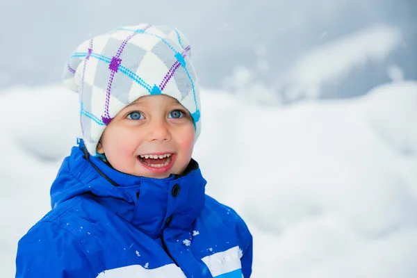 Зимовий хлопчик кидає сніжок — стокове фото