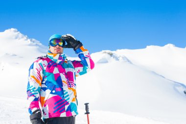 Young man with skis and a ski wear clipart
