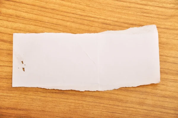 Torn paper on wood floor — Stock Photo, Image