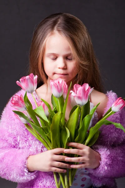 Beautiful little girl with bouquet of pink tulips — Stock Photo, Image