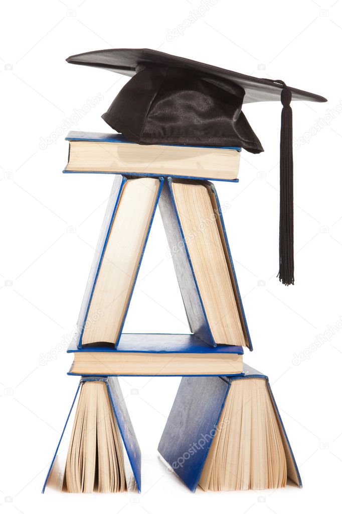 Books with black cap of bachelor isolated on white