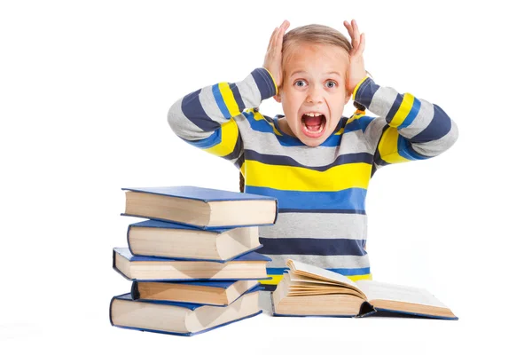 Schoolgirl with horror looking at pile of books on isolated white — Stock Photo, Image