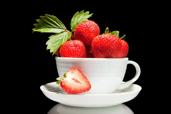 Röda jordgubbar i vit kopp på en svart bakgrund — Stockfoto