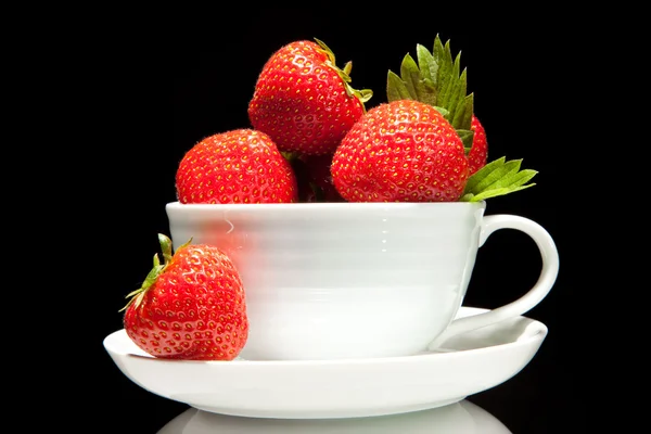 Fresa roja en taza blanca sobre fondo negro — Foto de Stock