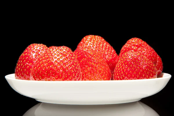 White saucer with red strawberr on a black background — Stock Photo, Image