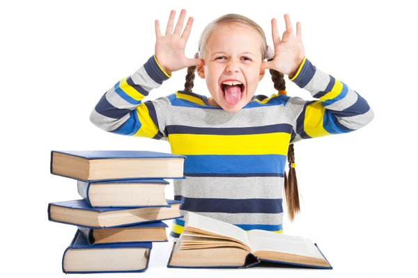Estudante com livros colocando a língua em branco isolado — Fotografia de Stock