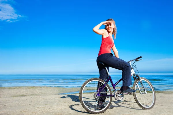 Bella donna con bicicletta al mare — Foto Stock
