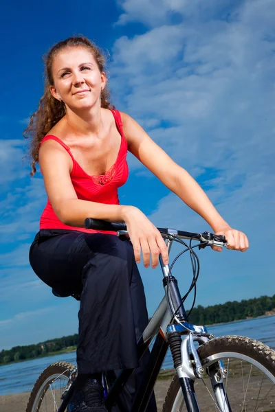 Красивая женщина с велосипедом у моря — стоковое фото