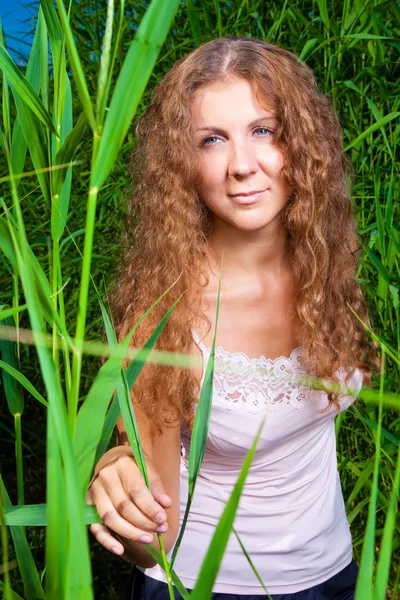 Piękna dziewczyna w różowym wśród wysokiej trawy zielone łąki lato — Zdjęcie stockowe