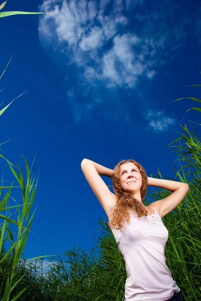 Piękna dziewczyna w różowym wśród wysokiej trawy zielone łąki lato — Zdjęcie stockowe