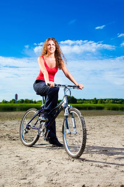Deniz kenarındaki bisiklet ile güzel bir kadın — Stok fotoğraf