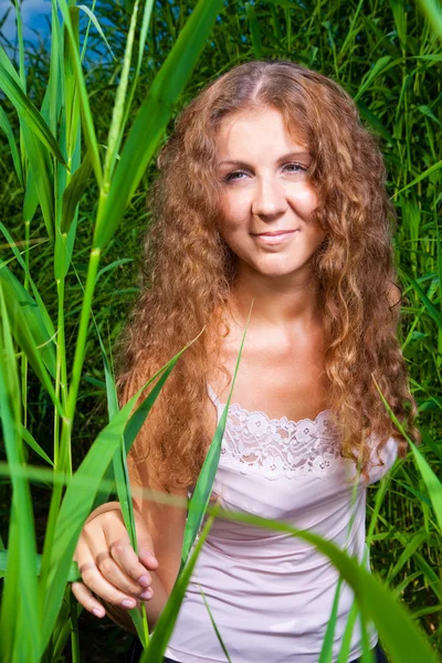 Güzel bir kız pembe arasında yüksek yeşil çimen yaz çayır — Stok fotoğraf