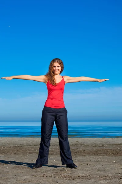 Girl doing morning exercises at the beach — Stock Photo, Image