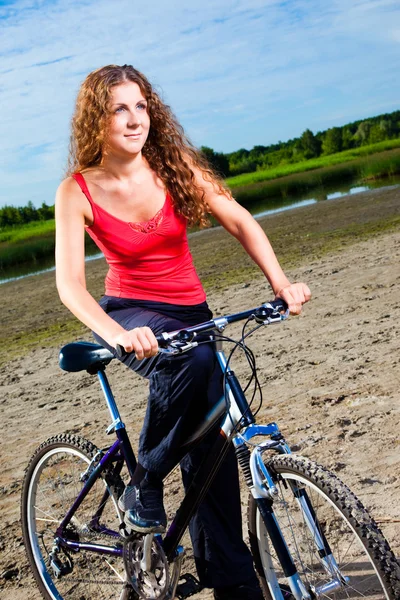 Schöne Frau mit Fahrrad am Meer — Stockfoto